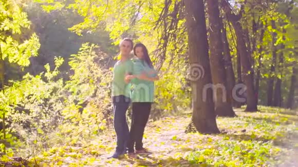 在秋天公园跳舞的一对年轻快乐的夫妇视频的预览图