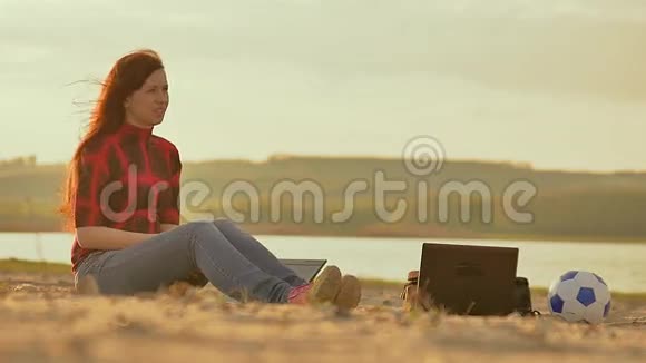 一个手提电脑女孩坐在沙滩上视频的预览图