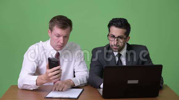 两名年轻的多民族商人在绿色背景下合作视频的预览图