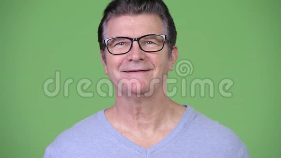 快乐英俊的老人戴着绿色眼镜微笑视频的预览图