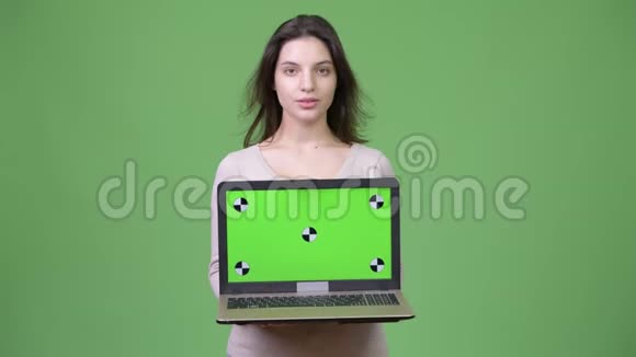 年轻漂亮的女人展示笔记本电脑视频的预览图