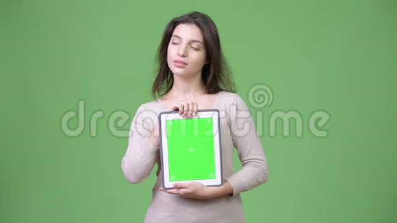年轻的美女一边思考一边展示数码平板电脑视频的预览图