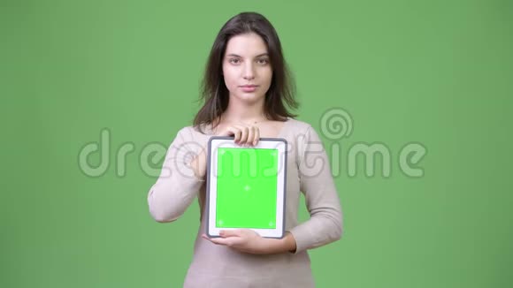 年轻漂亮的女人展示数字平板电脑视频的预览图