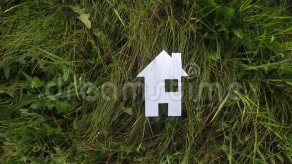 幸福家庭建设住宅理念纸屋矗立在大自然的绿草中生命象征生态视频的预览图