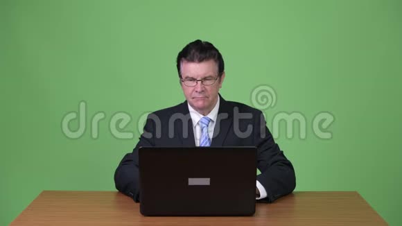 高级帅哥商人用笔记本电脑视频的预览图