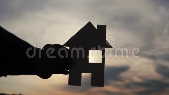 幸福家庭建设住宅理念男人手里拿着纸房手里拿着夕阳的剪影生活方式视频的预览图