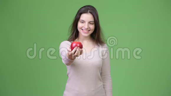 年轻快乐的美女抱着苹果视频的预览图
