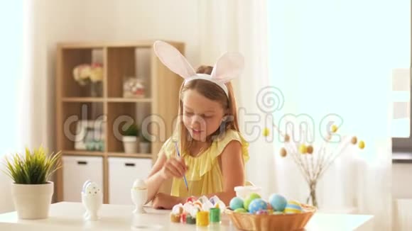 快乐女孩在家给复活节彩蛋上色视频的预览图