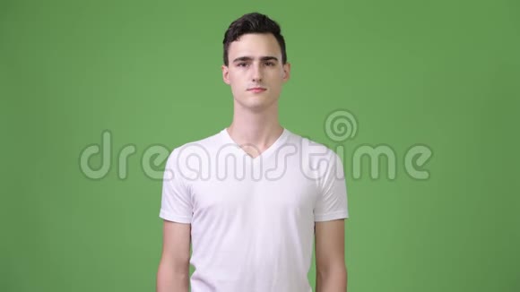 年轻快乐的帅哥在绿色的背景下微笑视频的预览图