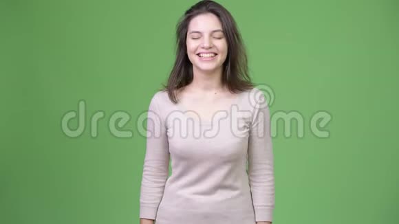 年轻快乐的美女在绿色的背景下笑视频的预览图