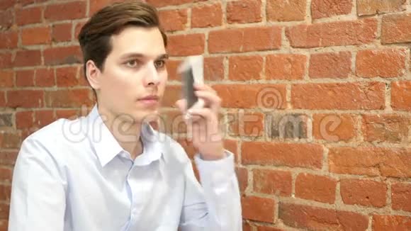 一个随便的年轻职业男人打电话视频的预览图