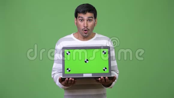 年轻英俊的波斯人展示笔记本电脑视频的预览图