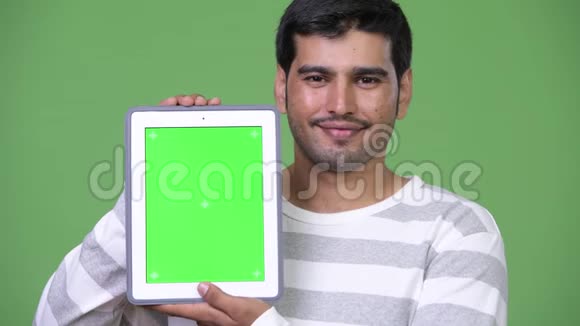 年轻英俊的波斯人展示数码平板电脑视频的预览图