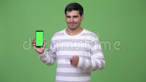 年轻英俊的波斯人展示电话视频的预览图