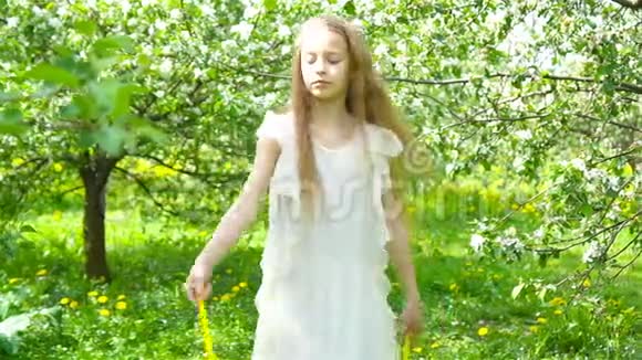 美丽的春日盛开的苹果园里可爱的小女孩视频的预览图