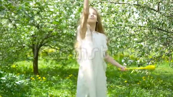 美丽的春日盛开的苹果园里可爱的小女孩视频的预览图