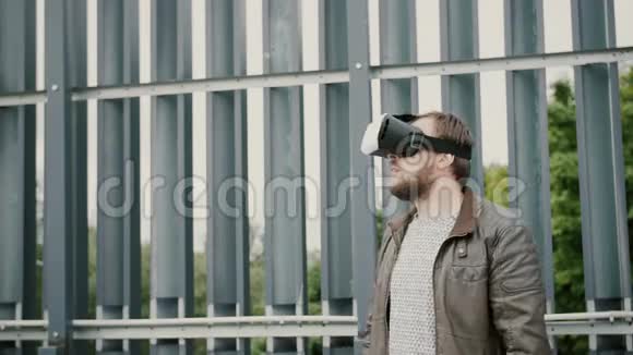 有胡子的帅哥在城市空间里使用虚拟现实眼镜4k视频的预览图