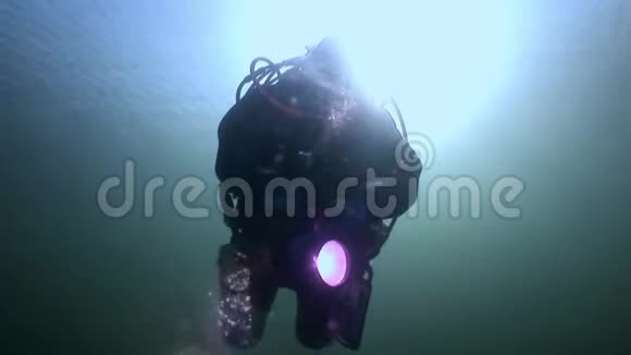 水肺潜水员剪影手电筒的背景反射阳光水下视频的预览图