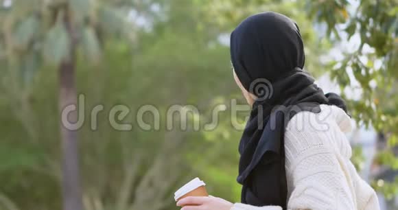 戴头巾的女人拿着咖啡杯4k视频的预览图
