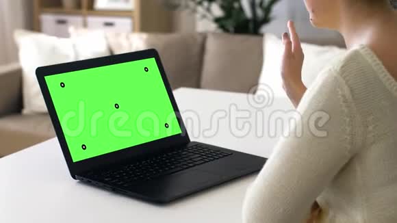 手提电脑上有彩色钥匙绿色屏幕的女人视频的预览图