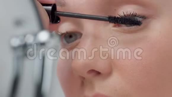 白种人女性带着没有化妆的带光镜检查她的皮肤并做面部护理视频的预览图