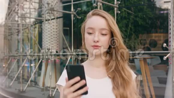 年轻红发女郎在城里用电话视频的预览图