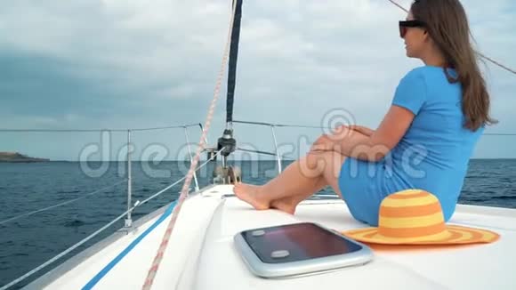 穿着黄色帽子和蓝色衣服的女人在海洋的夏季在游艇上休息视频的预览图