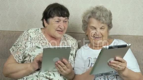 两个老女人拿着银色数码平板电脑视频的预览图