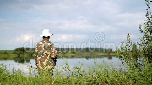 钓竿钓鱼的渔夫在湖边钓鱼视频的预览图