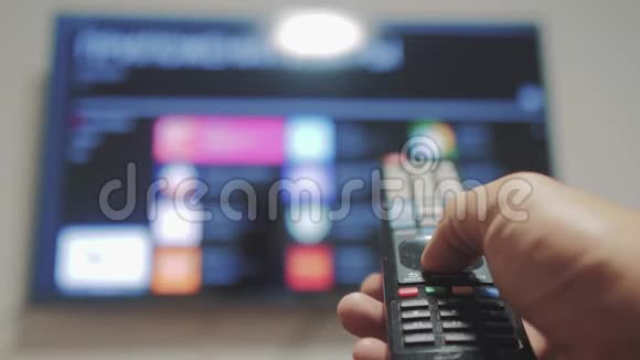 智能电视与应用程序和手男性手握遥控器关闭智能电视男人手控制生活方式电视视频的预览图