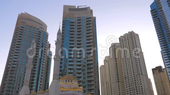 阿拉伯联合酋长国迪拜码头的穆斯林清真寺和玻璃摩天大楼视频的预览图