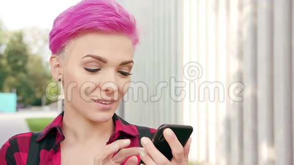小镇上有粉色短发的女人用电话视频的预览图