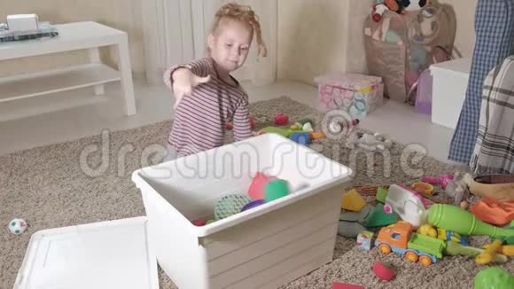 可爱的笑着的小男孩学龄前的金发女郎玩五颜六色的玩具坐在房间的地板上视频的预览图