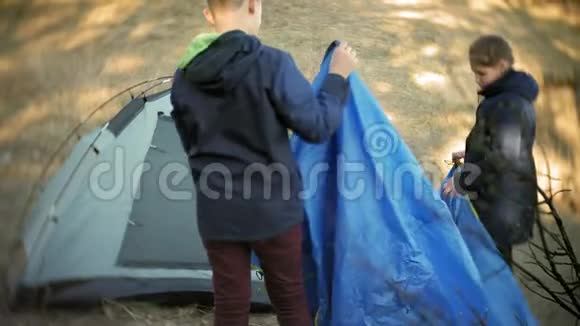 孩子们在森林里的大自然上聚集一个旅游帐篷视频的预览图