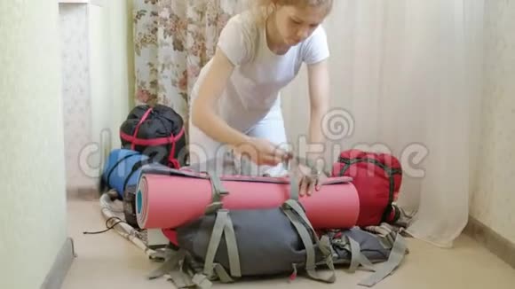 一位女游客在厨房里的背包里收集东西准备旅行视频的预览图