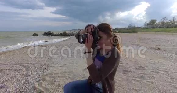 女孩摄影师在海滩工作视频的预览图