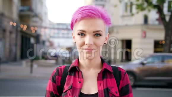 城里有一头粉红色头发的快乐微笑的女人视频的预览图