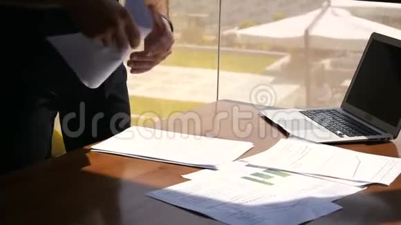办公室工作人员在笔记本电脑附近的桌子上整理文件视频的预览图