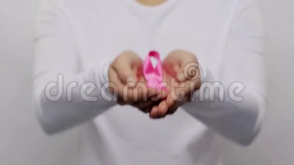 女人拿着粉红色的癌症意识丝带视频的预览图