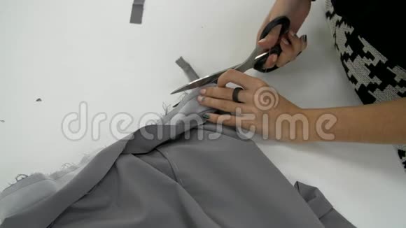 女性的双手割下一块灰色的布视频的预览图