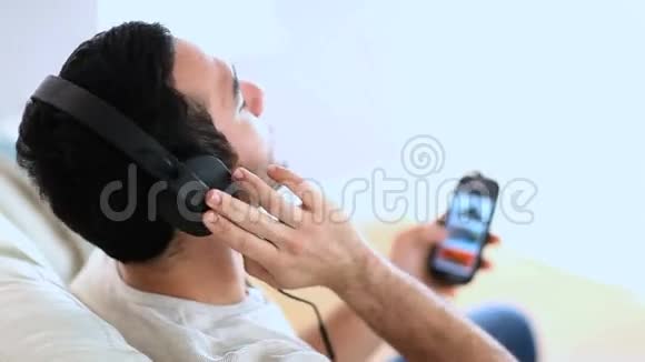开朗的男人用手机听音乐视频的预览图