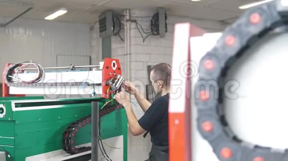穿工作服的电工在工厂里使用能源面板和机械设备视频的预览图