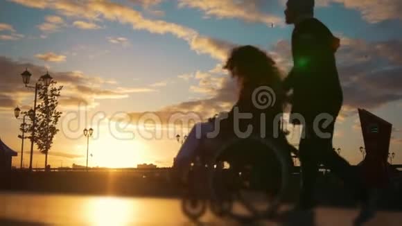 在日落时分一位坐在轮椅上的残疾女子在码头上行走视频的预览图