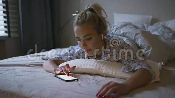 女人在床上听音乐视频的预览图