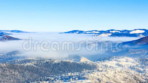 冬季景观冬天雾带着蓝天在山上移动视频的预览图