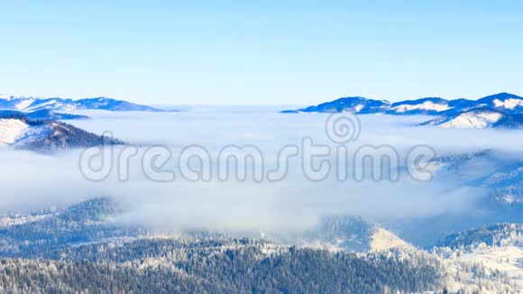 冬季景观冬天雾带着蓝天在山上移动视频的预览图