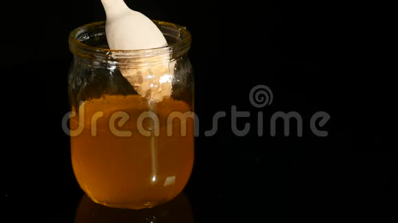 勺子把蜂蜜滴在罐子里视频的预览图