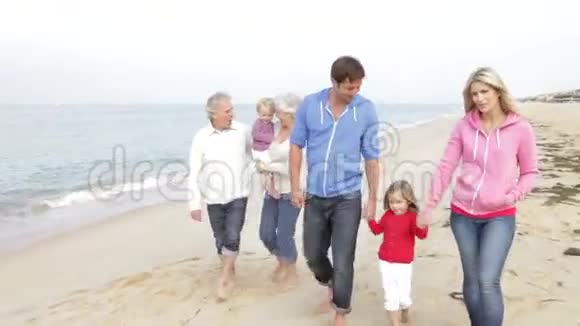 多代家庭一起沿着海滩漫步视频的预览图