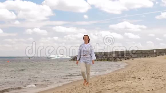 快乐微笑的女人漫步在夏日海滩视频的预览图
