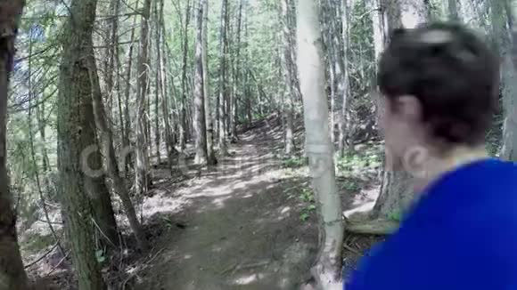 阳光明媚的一天男人在森林里奔跑视频的预览图